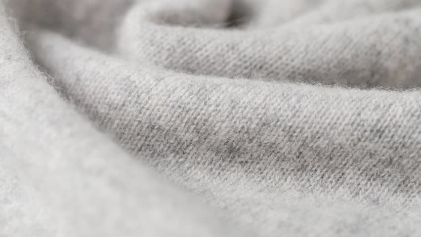 Camera glides across layered folds, revealing plush texture and fine stitches