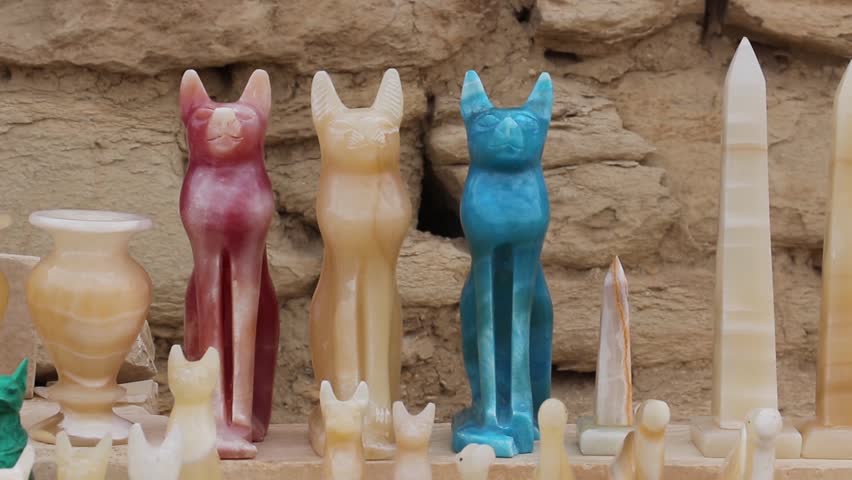 Close-up of a hand-carved stone statue of the ancient Egyptian goddess Bastet, depicted as a cat, symbolizing protection and fertility.