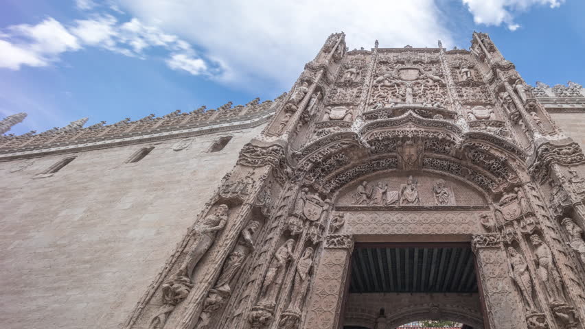 The Colegio de San Gregorio in Valladolid, seat of the National Museum of Sculpture timelapse with its intricate facade and passing clouds in blue sky. Looking up perspective. Castile and Leon, Spain