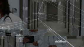 Following female doctor gesture, male colleague tapping tablet reviewing network charts in corridor. Medical, collaboration, technology, digital, healthcare, innovation, professional - Powered by Shutterstock - Get 15% off with code: PIKWIZARD15