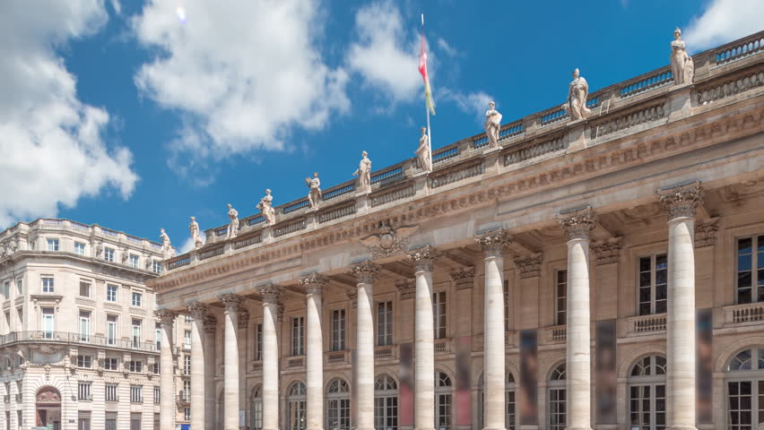 Grand Theatre de Bordeaux timelapse hyperlapse in France, home to the Opera National and Ballet National. A neoclassical architectural gem with colonnades. People walking under a blue cloudy sky