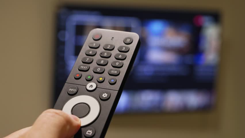 Male hand holding the TV remote control and turn on smart tv. Switching channels. High quality 4k footage