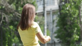A woman in a yellow shirt is creating bubbles with a large bubble wand. She is spending a relaxing moment outdoors in a green park in Simferopol, Crimea. - Powered by Shutterstock - Get 15% off with code: PIKWIZARD15