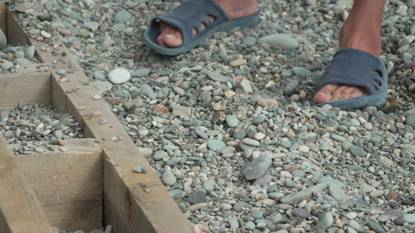 Pebbles Sorting Wood Person sifting small stones dropping onto wooden structure ground