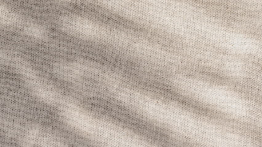 Camera pushes into knit linen weave, sunlight revealing fibers and warmth