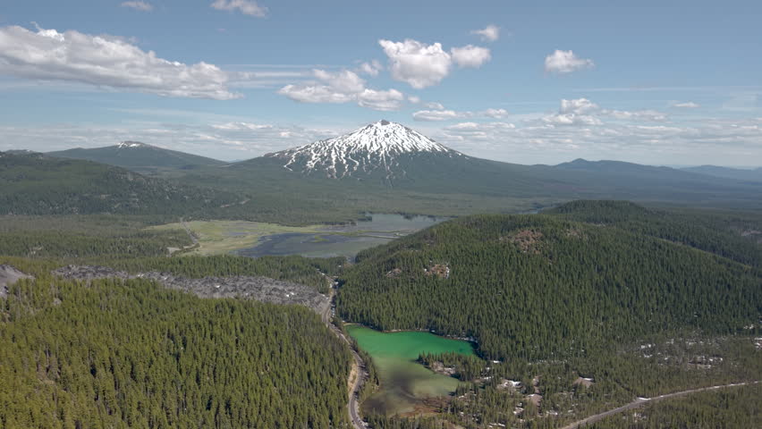 Panoramic view of Cascade Lakes Highway near Bend Oregon. Drone flight over lava, emerald colored Devils Lake and Mount Bachelor.