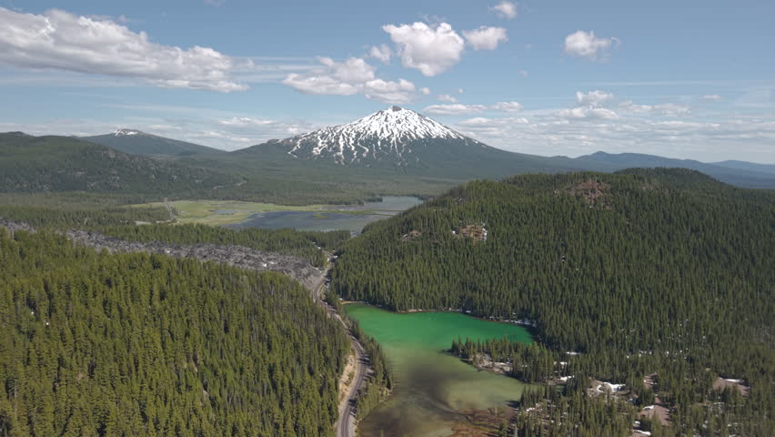 Devils Lake, Oregon. Drone flying towards lake. Snow-capped Mt Bachelor volcano in the distance.