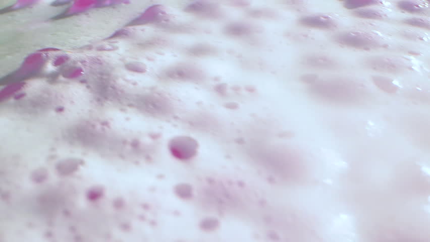 Close-up soap foam texture with pink gel balls, white shampoo soapsud background