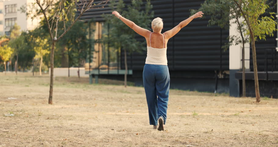 Middle age woman is in nature and taking relaxing walk.