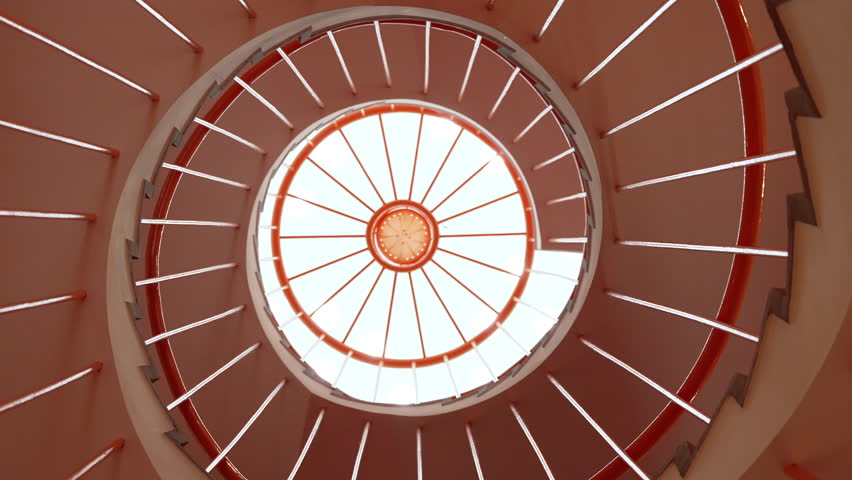 Modern round staircase ascending to bright overhead window.