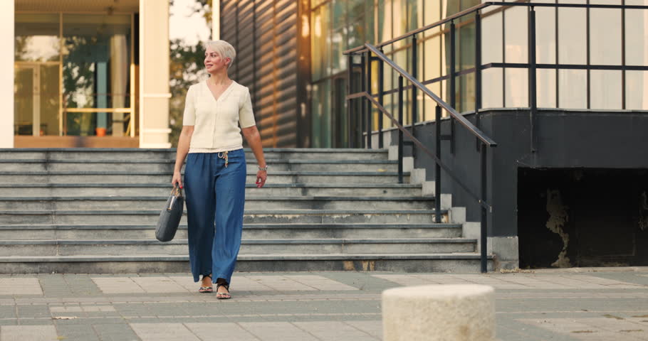 Happy middle age woman taking a walk to work. 