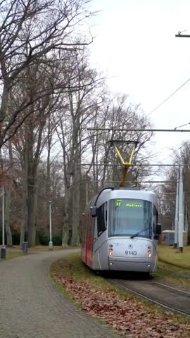 The red tram rides on rails in Prague