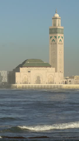 Hassan II mosque in Casablanca and Atlantic ocean waves at sunset, Morocco. Vertical video
