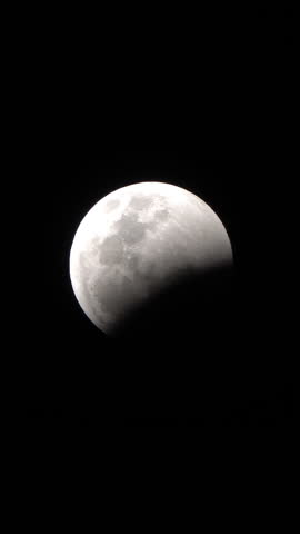 Lunar eclipse - the shadow of the Earth creeps on the Lunar disk. Vertical video