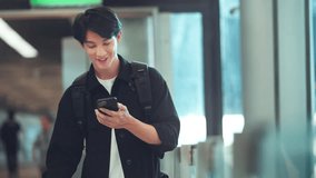 Happy Asian man with backpack using mobile smartphone standing with suitcase booking travel tickets via mobile application at airport terminal, Browse Internet, flight check in, Tourist journey trip - Powered by Shutterstock - Get 15% off with code: PIKWIZARD15