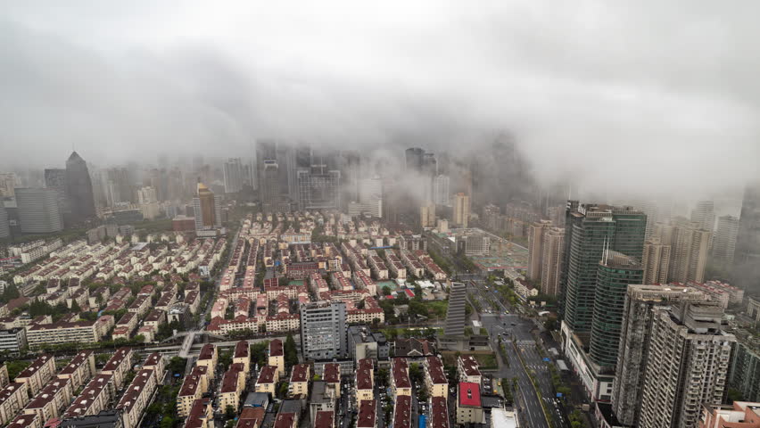 SHANGHAI, CHINA - 11 JUNE 2025 : Timelapse of the amazing Shanghai city skyline from a high vantage point on a foggy cloud covered day