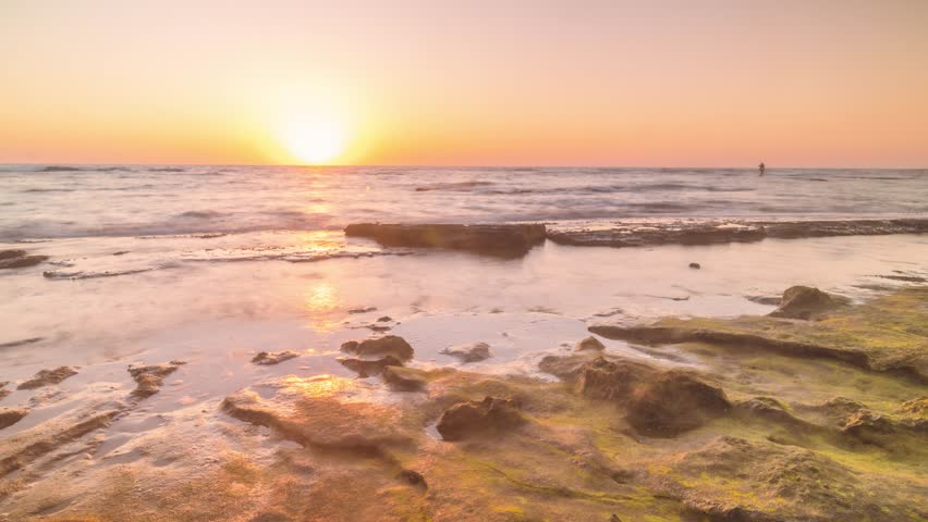 4K Timelapse view of the waves crashing on the rocks during sunset in the sea of Mikhmoret, Israel
