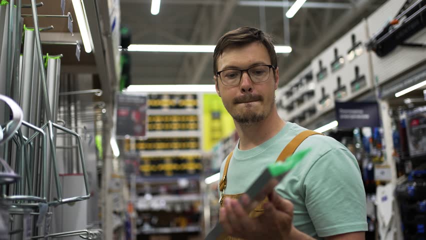Handyman carefully inspecting spirit level, ensuring accuracy and precision for upcoming construction project in bustling hardware store