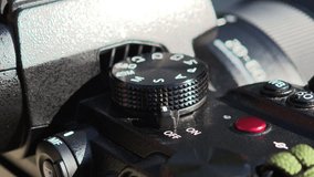 Photographer's finger rotating the mode dial of a modern mirrorless camera - Powered by Shutterstock - Get 15% off with code: PIKWIZARD15