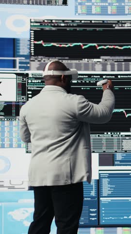 Vertical Video High tech startup entrepreneur using virtual reality glasses to examine KPI models, reviewing infographics and working on business productivity. Professional VR gadget simulation