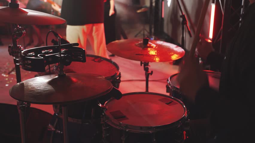 Rock concert of a cover band. Close-up of the hands of a drummer playing drums during a concert, party. A guy plays drums, hits cymbals and drumsticks with sticks. Drum kit during a concert, side view