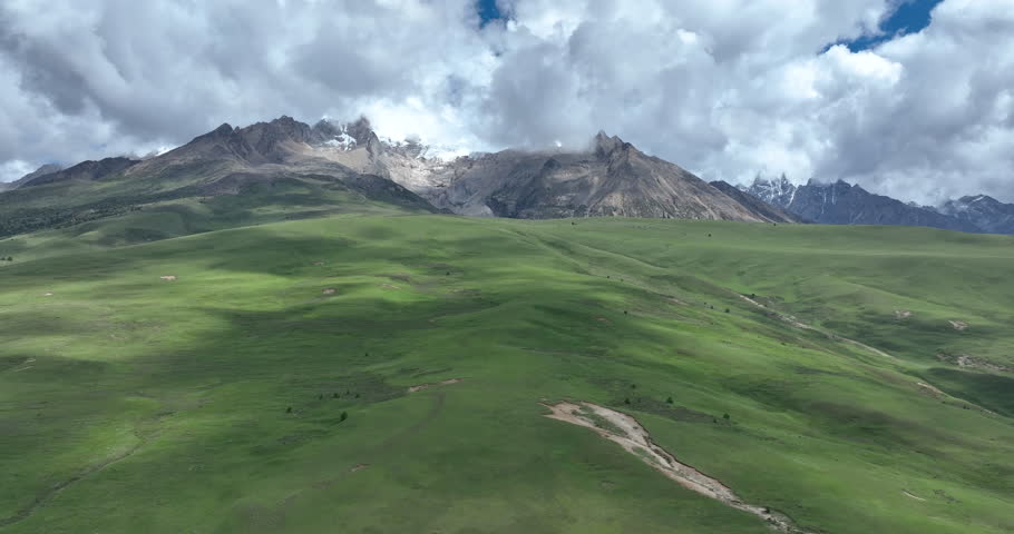 Aerial footage of beautiful high altitude snow capped mountains and grassland landscape in China