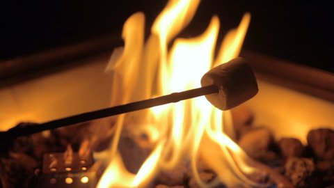 Close up of marshmallows roasting on an open flame.