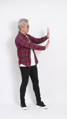 The elderly East Asian man wearing a red plaid shirt is standing against a white background.