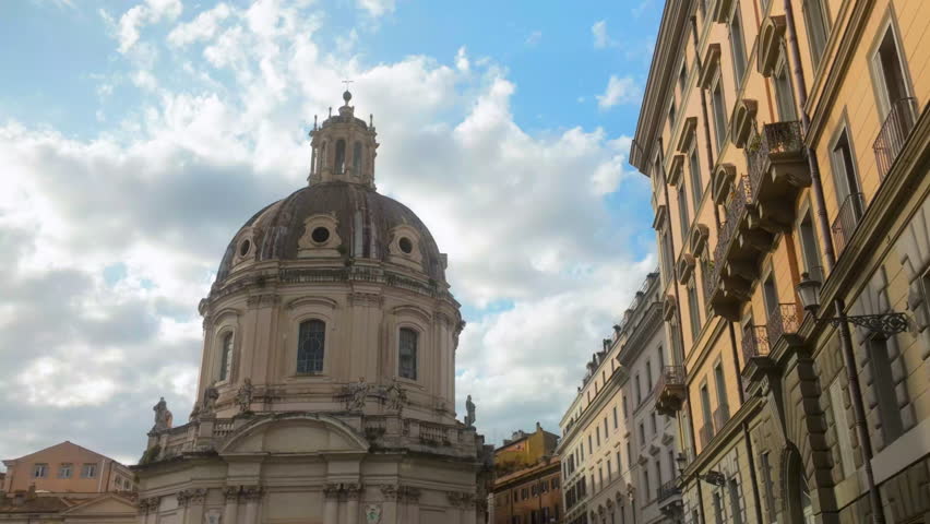 View of the Church of the Most Holy Name of Mary in Rome surrounded by historic buildings under a bright sky.