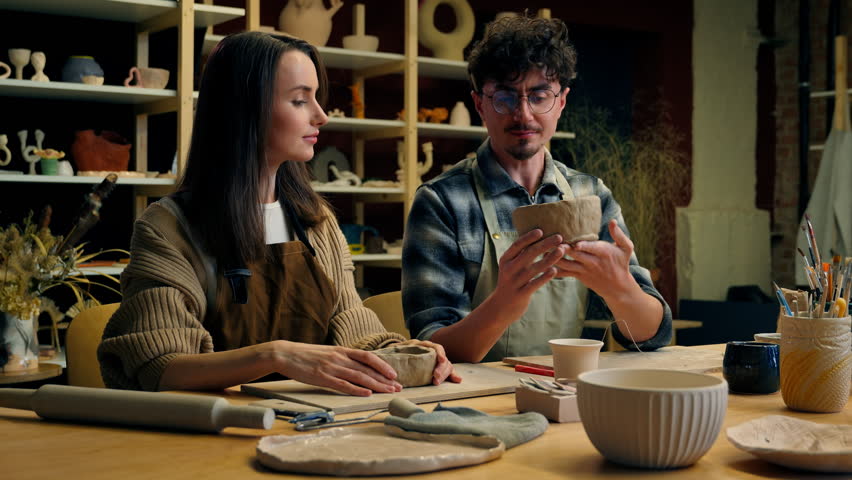 Caucasian man woman girl guy romantic date couple together modeling clay ceramics teacher student artist potter in pottery workshop teaching handmade sculpting create bowls pots art handcraft crockery