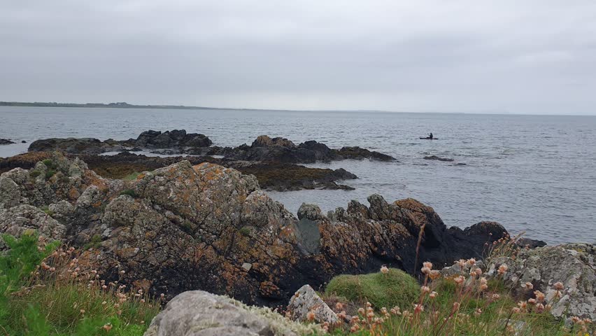 Man Rowing a Boat on the Ocean under Cloudy Sky – Solitude and Strength in Nature