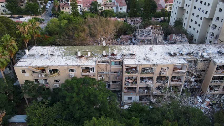 Nearly vertical drone circle shows rooftop and structural damage from missile strike in Tel Aviv.