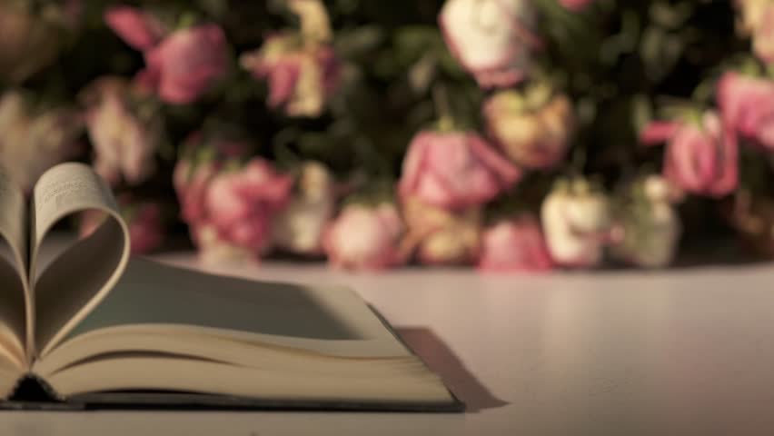 
bouquet of withered rose flowers and open book with heart