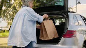 Older Caucasian mature business woman shopper customer senior buyer client female elderly lady car auto driver opening automobile trunk put loading shopping bags in vehicle delivery order in park city - Powered by Shutterstock - Get 15% off with code: PIKWIZARD15