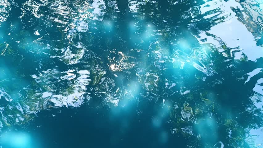 Close-up of the blue sea water rippled with sunlight reflecting off the surface of a swimming pool, creating a calm abstract pattern.