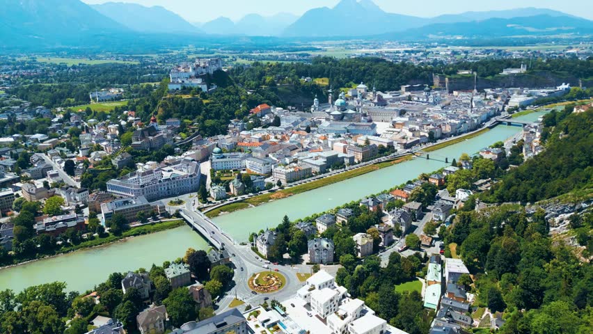 Salzburg, Austria, aerial view of the historic old town with Hohensalzburg Fortress, Salzach River, baroque architecture and surrounding Alps. Captured on a sunny summer day from a drone