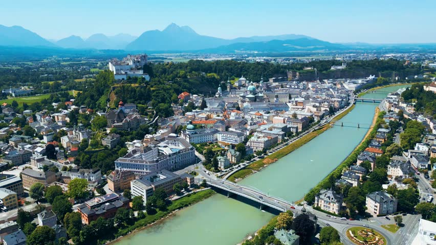 Salzburg, Austria, aerial view of the historic old town with Hohensalzburg Fortress, Salzach River, baroque architecture and surrounding Alps. Captured on a sunny summer day from a drone
