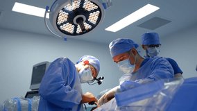 Surgeon in surgical loupes puts efforts to apply a medical instrument. Medical team working in the operating room. - Powered by Shutterstock - Get 15% off with code: PIKWIZARD15