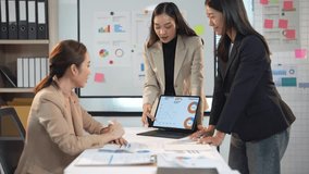 Team of business professionals analyzing charts on a laptop during a meeting in a modern office setting - Powered by Shutterstock - Get 15% off with code: PIKWIZARD15