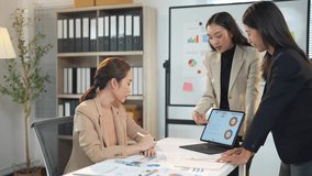 Colleagues discussing project details around a table, using a laptop for data visualization during a meeting. Engaged business professionals working together - Powered by Shutterstock - Get 15% off with code: PIKWIZARD15