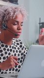 Young African American woman is actively participating in an online conference while wearing a headset. She shows enthusiasm and engagement in the conversation, showcasing her professional demeanor. - Powered by Shutterstock - Get 15% off with code: PIKWIZARD15