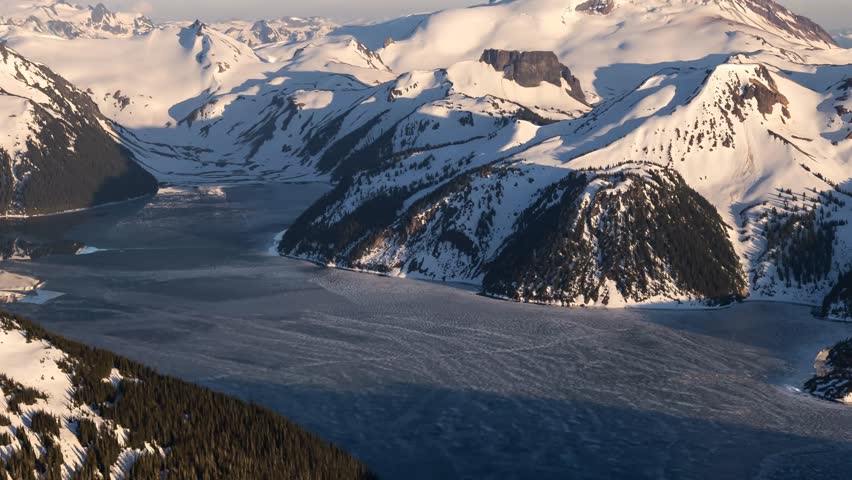 Majestic Aerial View of Snow-Capped Mountains and Icy Lake in Beautiful British Columbia, Canada
