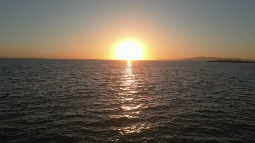 Drone flies forward into peaceful ocean sunset at Seal Beach (60fps)