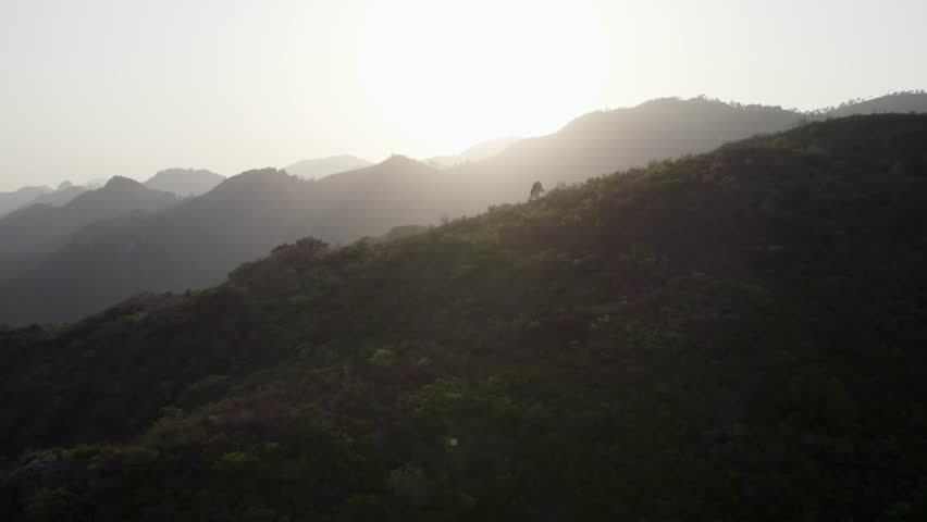 Golden sun sets behind forested ridgelines of Margalla Hills in Islamabad. Islamabad, Pakistan