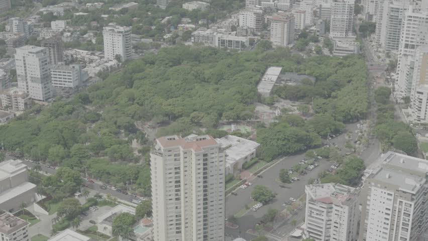 Santo Domingo, Dominican Republic – June 22, 2025: Aerial drone footage capturing a large modern building with the city skyline of Santo Domingo in the background, 4k raw color video.