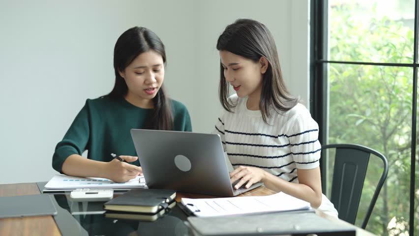 Two Asian women working together in an office