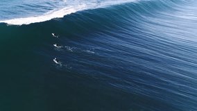 Deep blue wave forming with underwater clarity and steep wall, tropical surf conditions as surfers pass over top, aerial overview with rainbow in mist - Powered by Shutterstock - Get 15% off with code: PIKWIZARD15