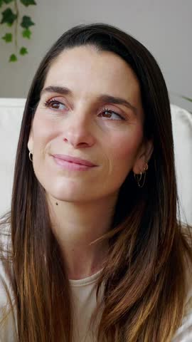 Vertical HD video of young pretty adult woman relaxing and breathing, enjoying peaceful atmosphere in a comfortable chair in her tranquil home