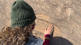 Iranian curly hair woman with red dress touch the golden sand desert in Saudi wonderful nature landscape close up dune fine sand pouring landscape of orange sky summer outdoors traveler journey - Powered by Shutterstock - Get 15% off with code: PIKWIZARD15