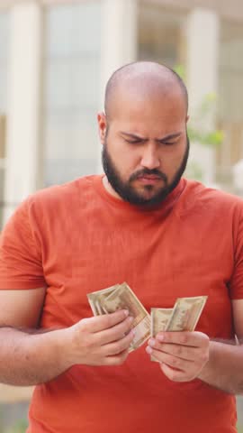 Vertical Video of Confused Bald indian Man Counting Money, Indian Rupees